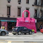 A large pink bag sitting on the side of a road