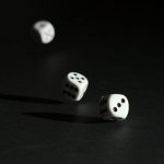 3 white dice on black surface