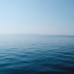 body of water under blue and white sky at daytime