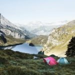 red and gray tents in grass covered mountain